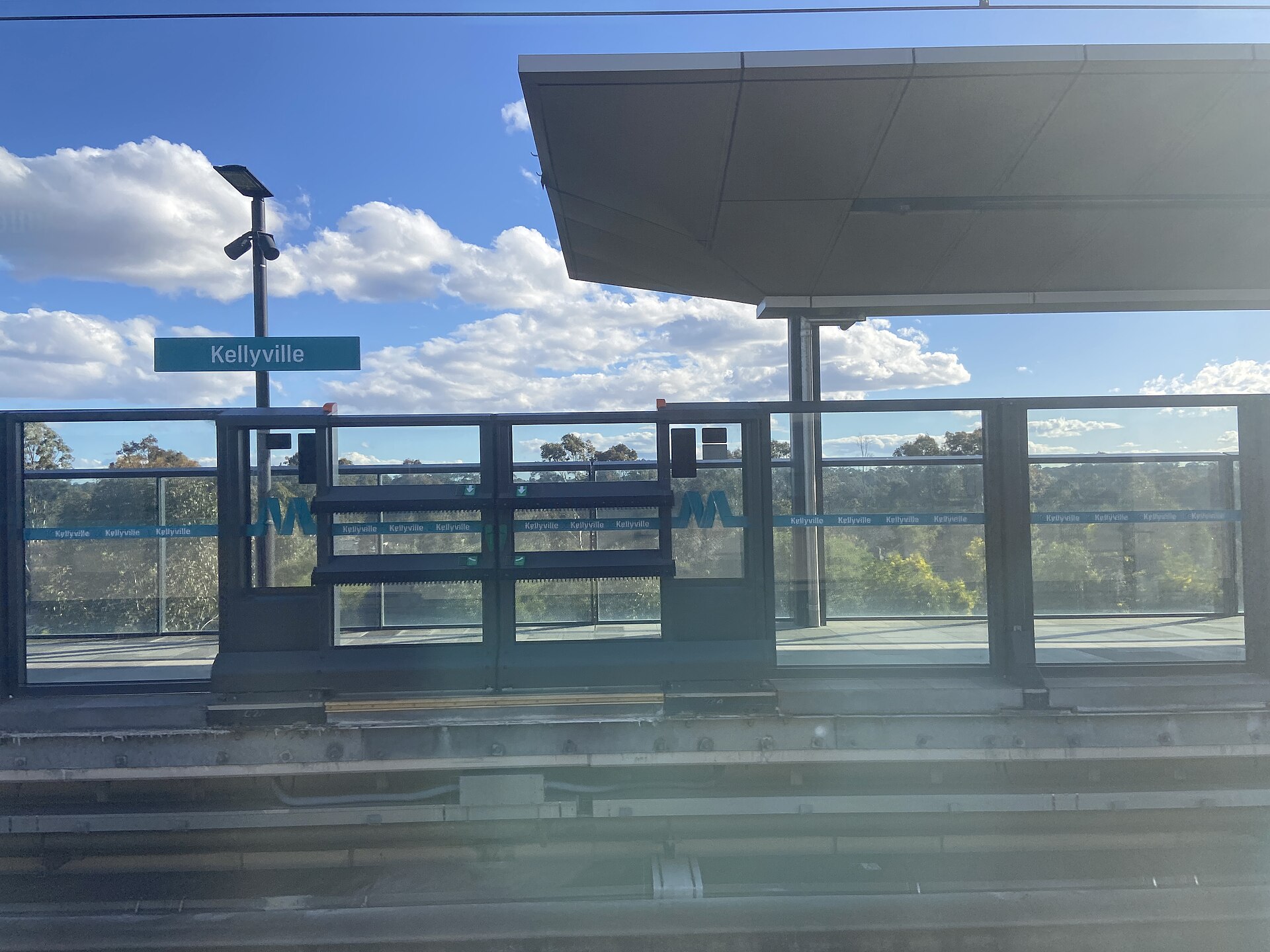 Kellyville metro station with wooded land beyond the platform